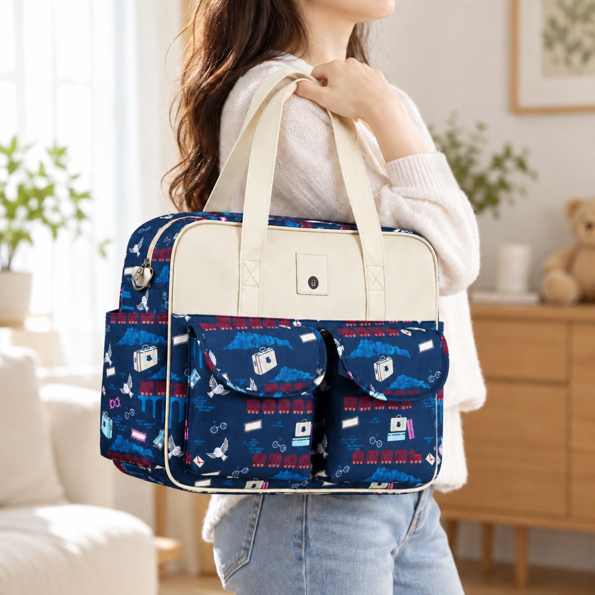 Sac à langer multipoches motif École Magique porté à la main en intérieur