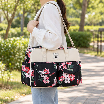 Sac à langer multipoches motif Floral noir et Blanc porté à l’épaule en extérieur