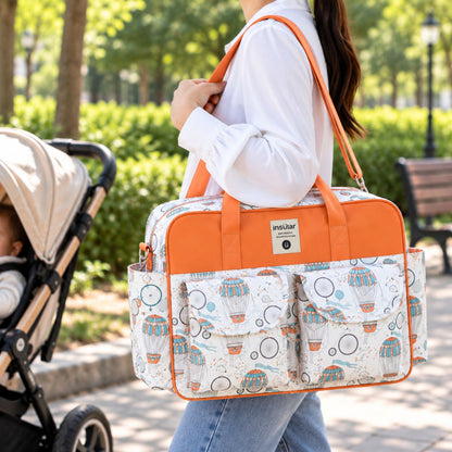 Sac à langer multipoches motif Montgolfière porté à l’épaule près d’une poussette