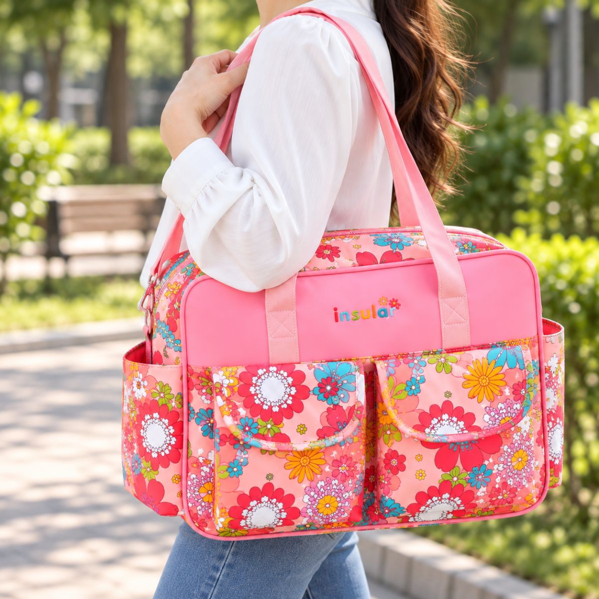Sac à langer multipoches motif Peinture Rose porté à l’épaule en extérieur