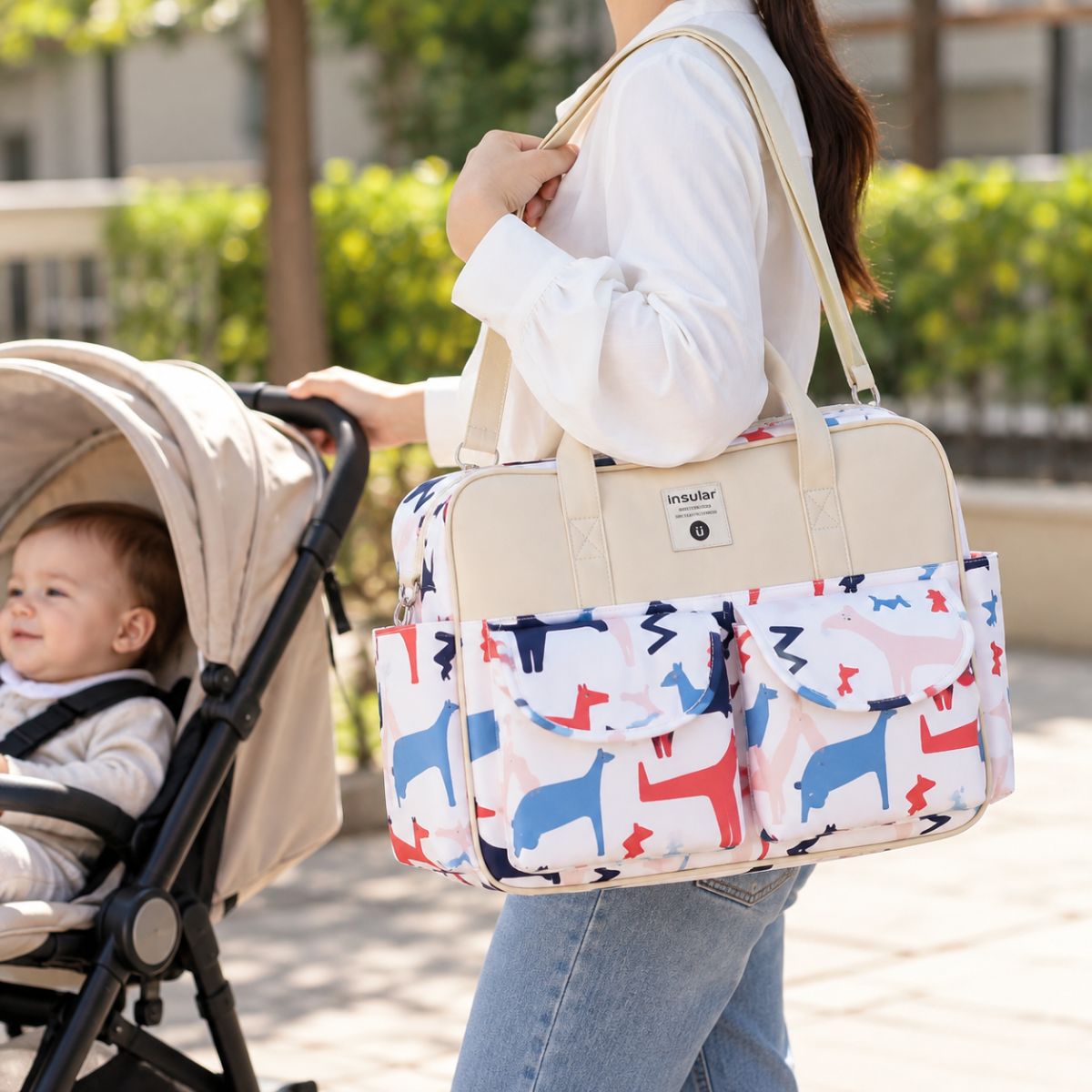 Sac à langer multipoches motif Poney Galopant porté à l’épaule près d’une poussette