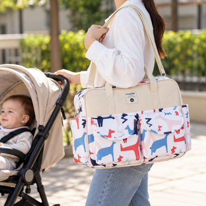 Sac à langer multipoches motif Poney Galopant porté à l’épaule près d’une poussette
