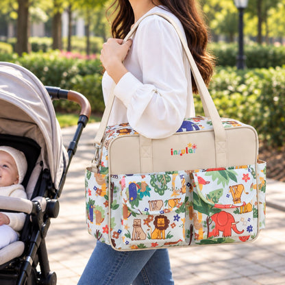 Sac à langer multipoches motif Style animalier porté à l’épaule près d’une poussette