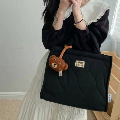 Sac a langer noir matelasse porte a l’epaule, accessoire pratique avec porte cles ours decoratif