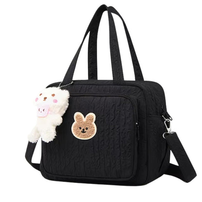 Vue de face d’un sac a langer noir orné d’un dessin de lapin et fermeture à cordon