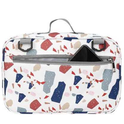 Vue arrière d'un sac a langer avec motif terrazzo et poche zippée ouverte pour téléphon
