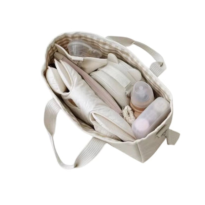 Sac a langer ouvert contenant biberons, couches et accessoires bien rangés