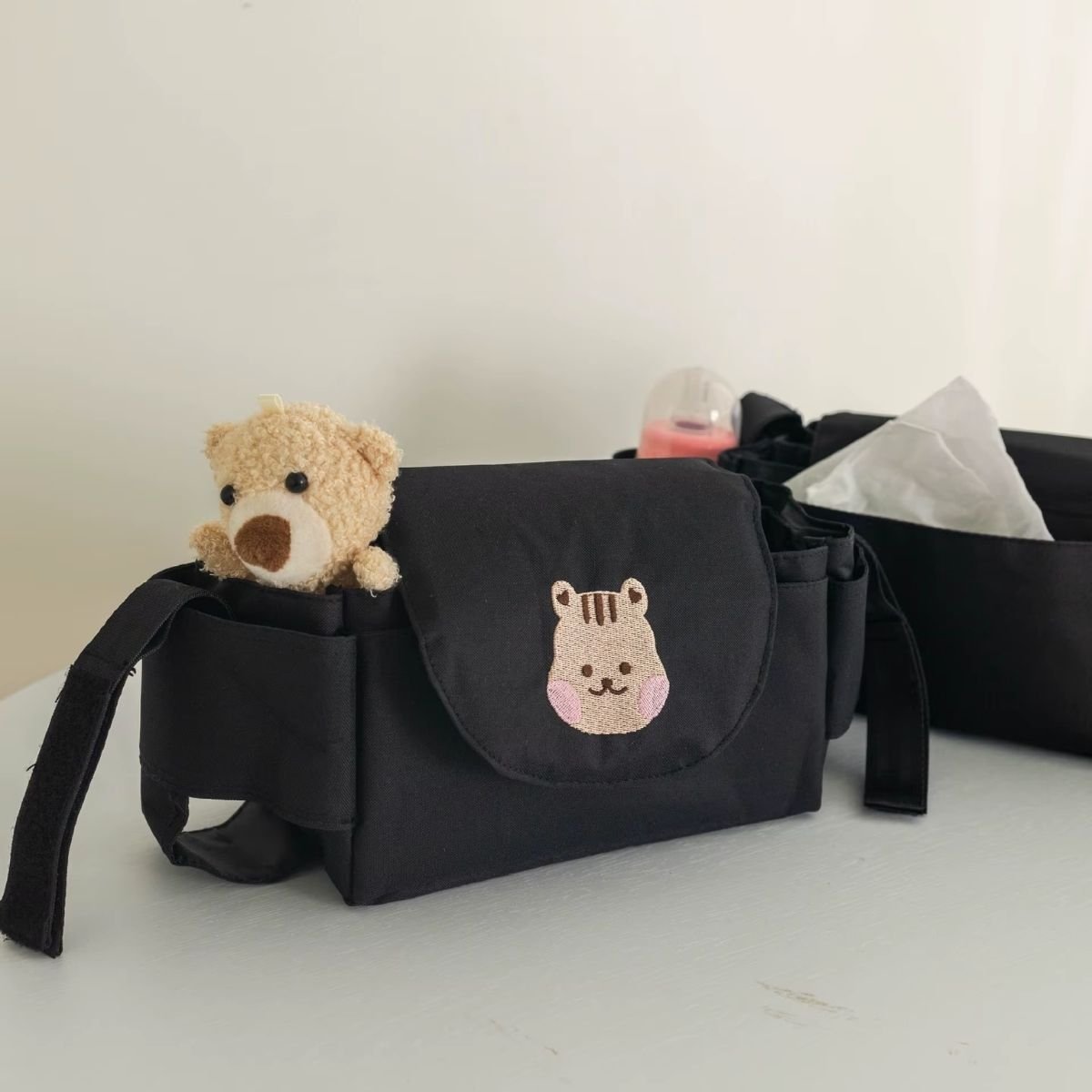 Sac a langer pour poussette motif écureuil noir avec jouet ours en peluche et biberon