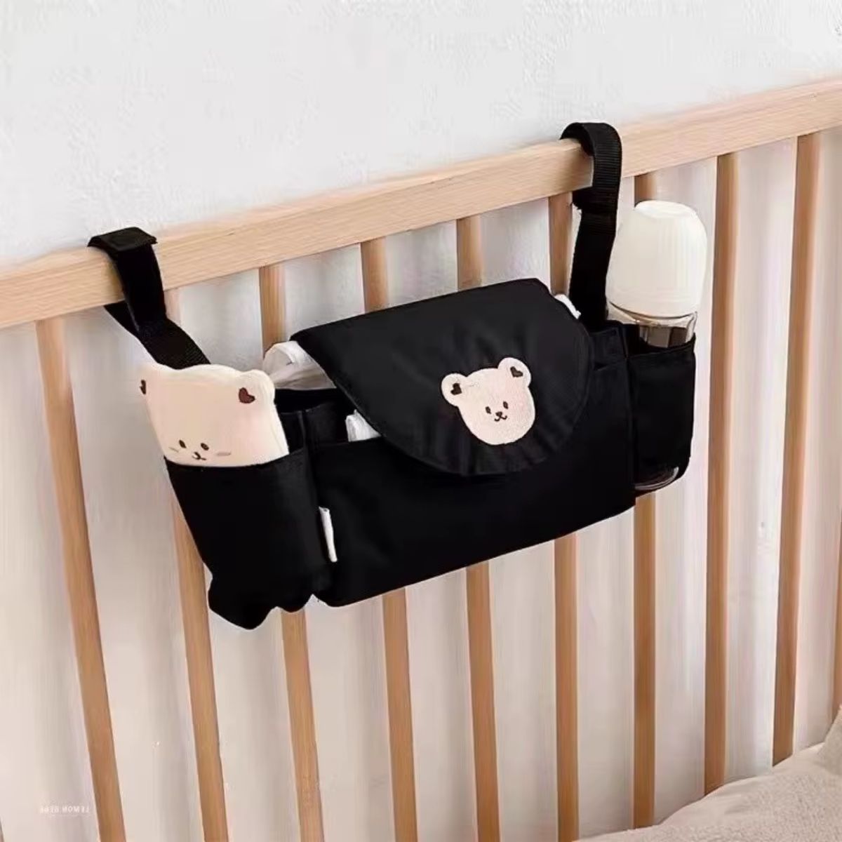 Sac a langer pour poussette motif ours beige accroché sur lit bébé avec biberon