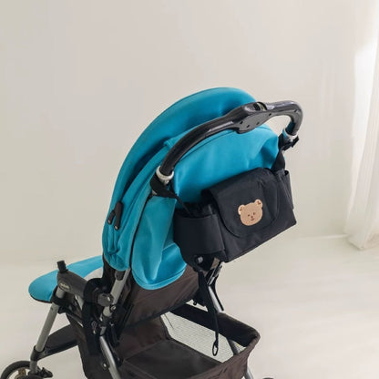 Sac a langer pour poussette motif ours beige fixé sur poussette bleue