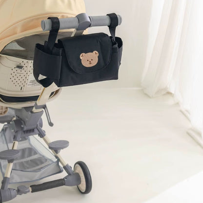 Sac a langer pour poussette motif ours beige attaché à une poussette beige