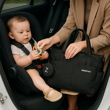 Sac a langer noir dans une voiture, maman tend un jouet coloré à bébé assis en siège auto