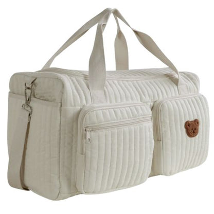 sac a langer creme avec un ours brode sur la poche vu en angle