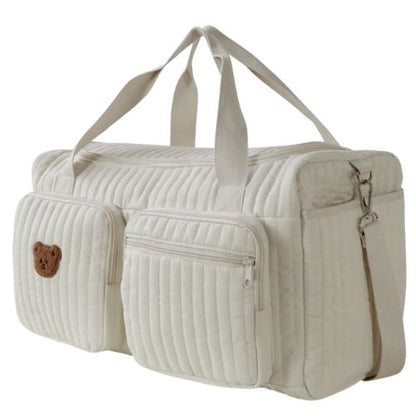 sac a langer creme avec un ours brode sur la poche vu en angle