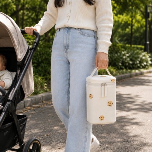 Sac à motifs pour biberon tigres porté par sa poignée intégrée lors d’une sortie avec bébé