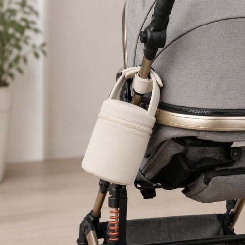 Sac cylindrique pour biberons beige avec poignée auto-agrippante fixé à une poussette