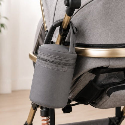Sac cylindrique pour biberons gris avec poignée auto-agrippante fixé à une poussette
