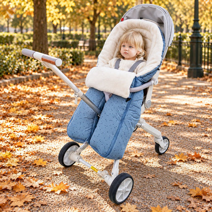 Sac de couchage pour poussette bleu clair à jambes séparées avec intérieur blanc pendant une promenade au parc en automne
