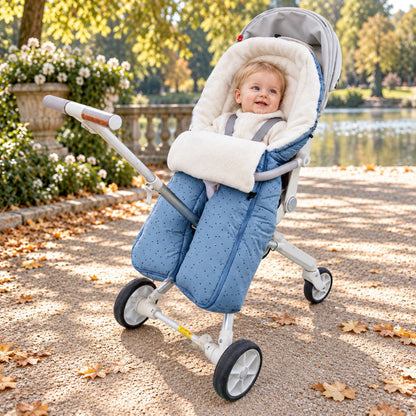 Sac de couchage pour poussette bleu clair à jambes séparées avec intérieur blanc doux et bébé dans un parc