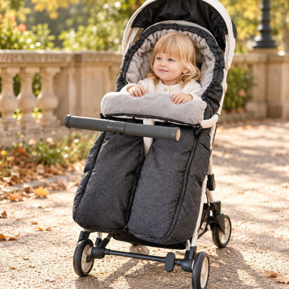 Sac de couchage pour poussette gris anthracite à jambes séparées avec intérieur gris doux et bébé dans un parc