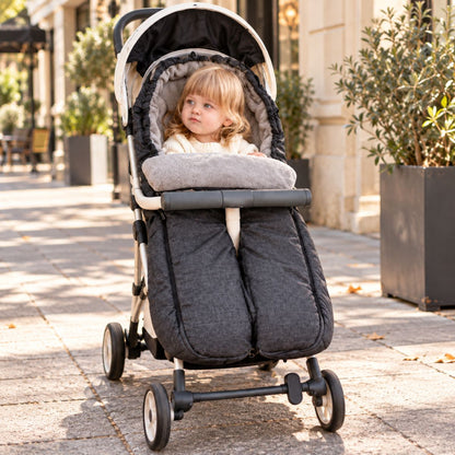 Sac de couchage pour poussette gris anthracite à jambes séparées avec bébé pendant une promenade en ville