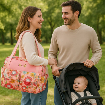 Sac de maternité dame rose porté à l’épaule par une maman souriante en extérieur