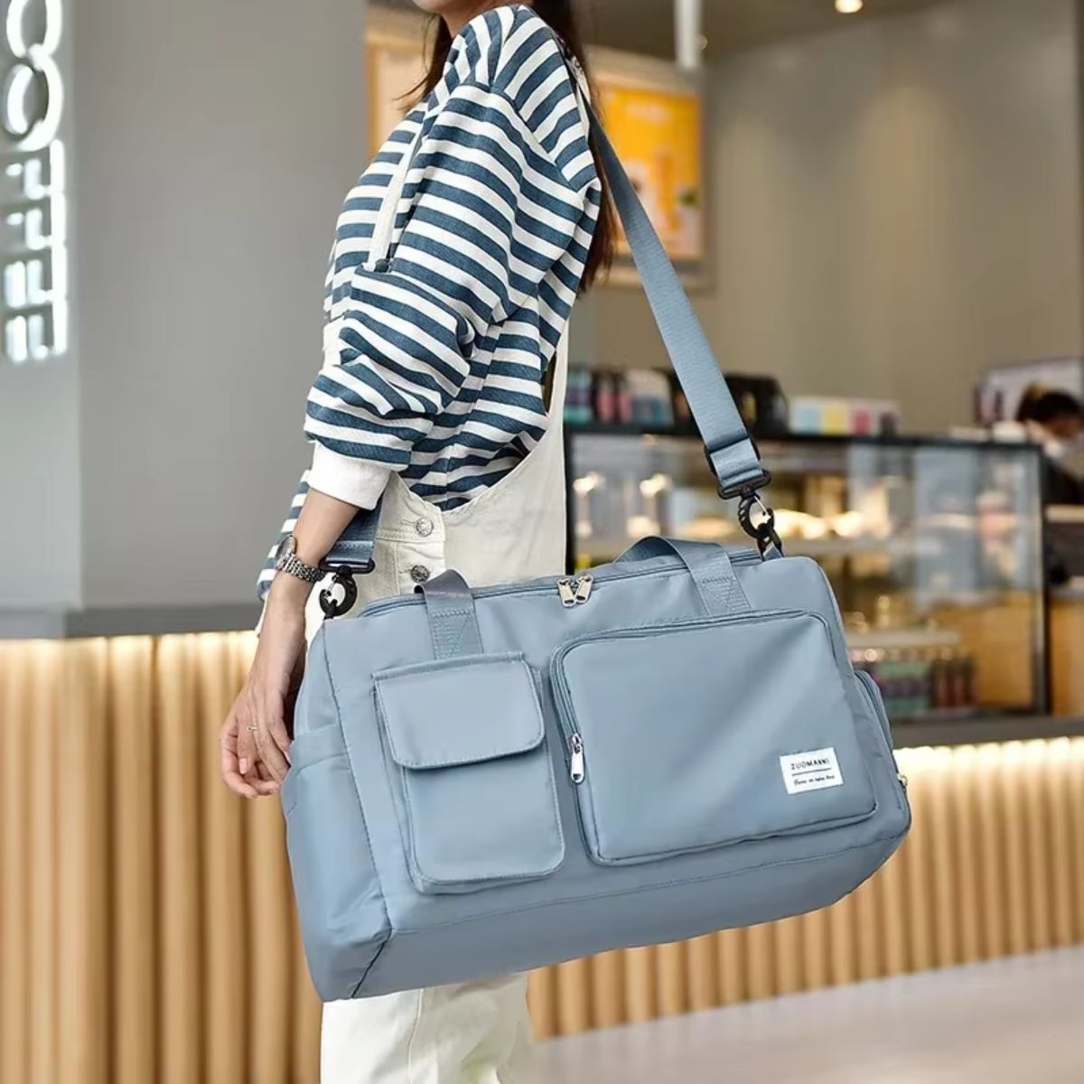 Sac de voyage avec compartiment chaussures bleu gris porté en bandoulière