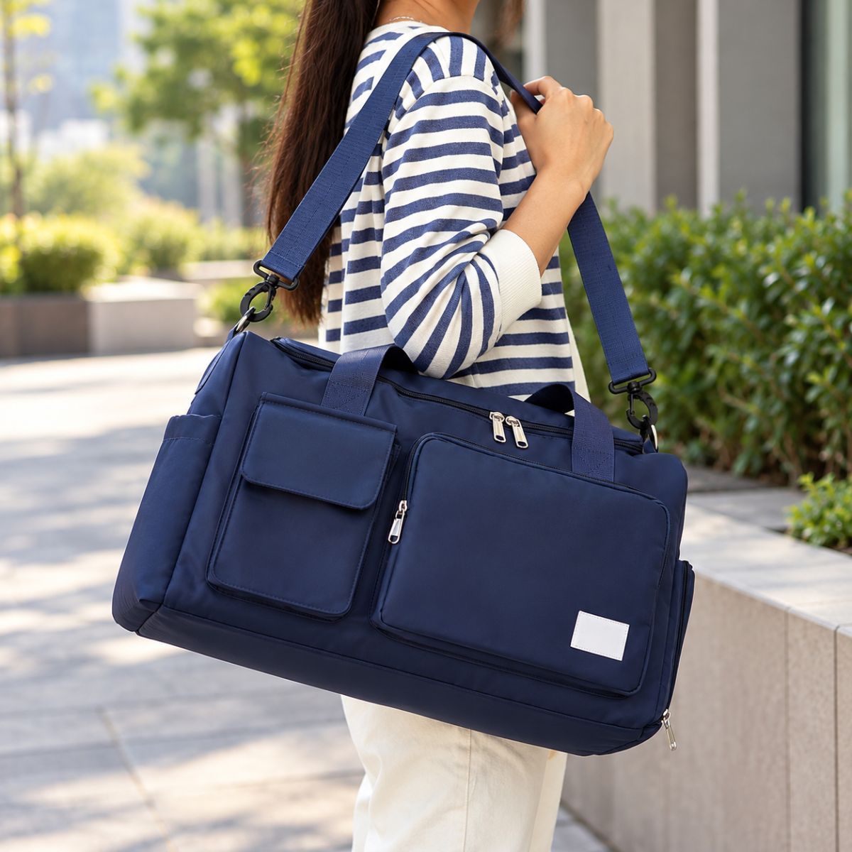 Sac de voyage avec compartiment chaussures bleu marine porté à l’épaule