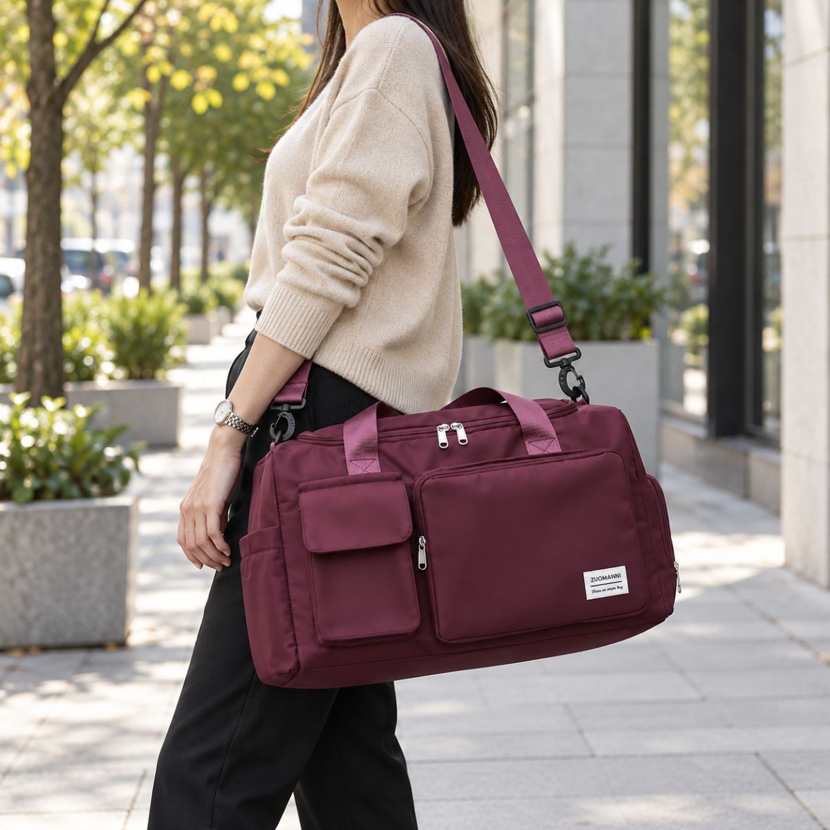 Sac de voyage avec compartiment chaussures bordeaux porté à l’épaule