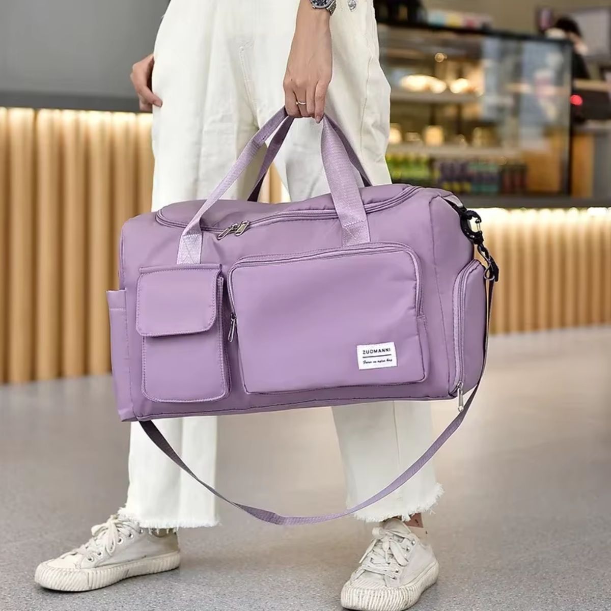 Sac de voyage avec compartiment chaussures lavande porté à la main