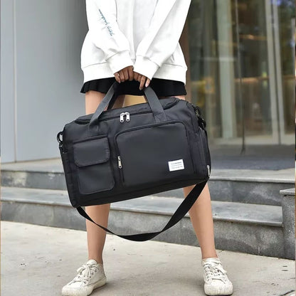 Sac de voyage avec compartiment chaussures noir porté à la main