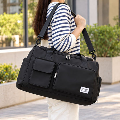Sac de voyage avec compartiment chaussures noir porté à l’épaule