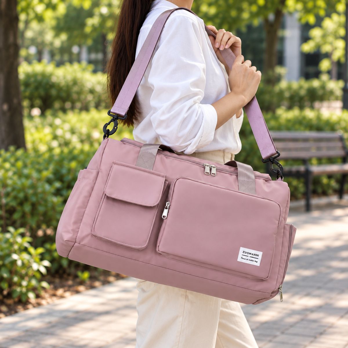 Sac de voyage avec compartiment chaussures rose poudré porté à l’épaule