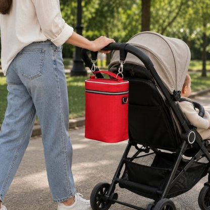 Sac isotherme multifonction pour biberons rouge fixé à une poussette lors d’une sortie