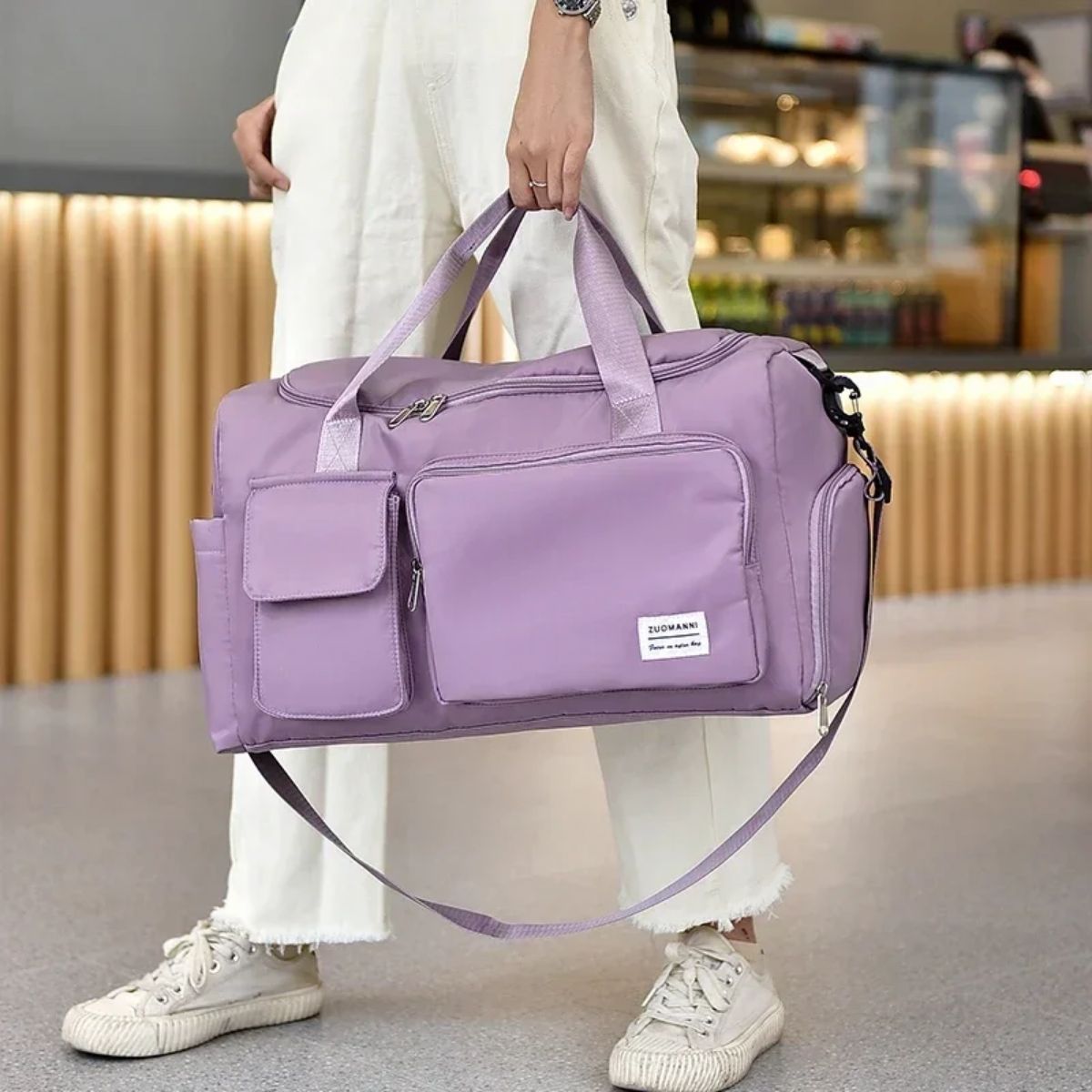 Sac maternité violet clair porté à la main avec bandoulière