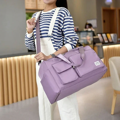 Sac maternité violet clair en bandoulière, porté par une maman