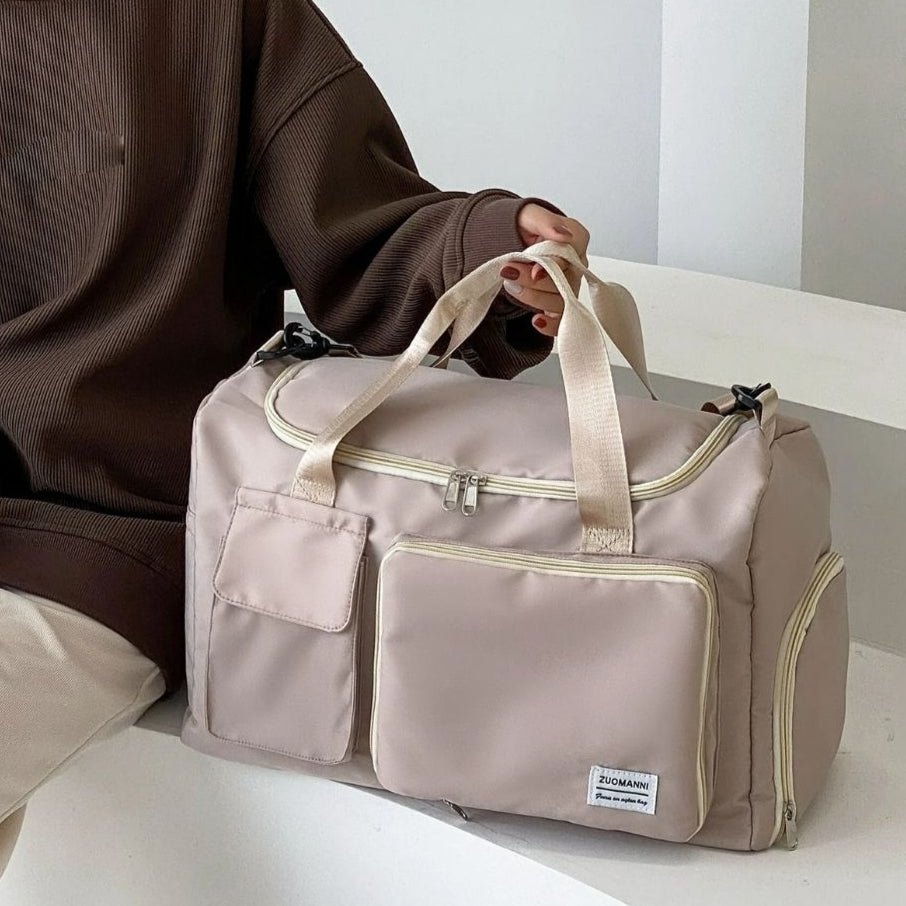 Sac maternité beige posé sur les genoux d’une femme assise