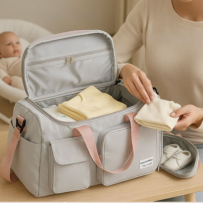 Intérieur d’un sac maternité rose grisé ouvert avec vêtements rangés