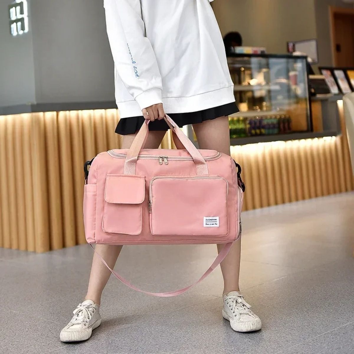 Vue en intérieur d’un sac maternité rose porté à la main