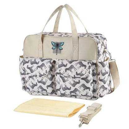  sac pour bebe zèbre graphique vu en angle avec tapis de change et bandoulière assortie posés à plat