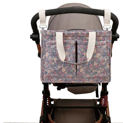 Sac pour bebe attaché à une poussette avec sangles robustes et accès facile aux poches