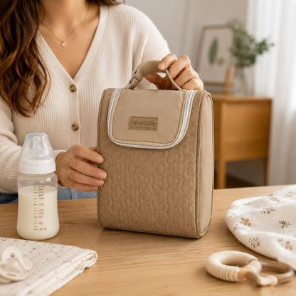Sac pour deux biberons marron avec poignée intégrée, présenté avec un biberon sur une table