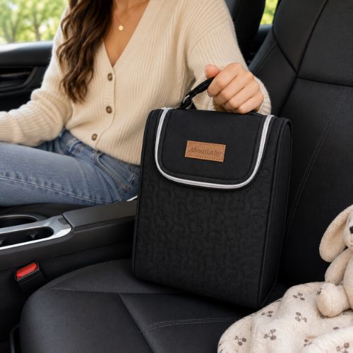 Sac pour deux biberons noir avec poignée intégrée, transporté à la main dans une voiture