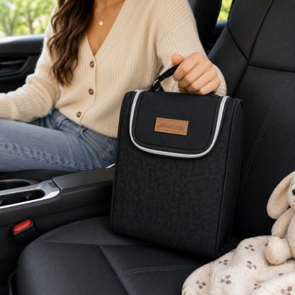 Sac pour deux biberons noir avec poignée intégrée, transporté à la main dans une voiture