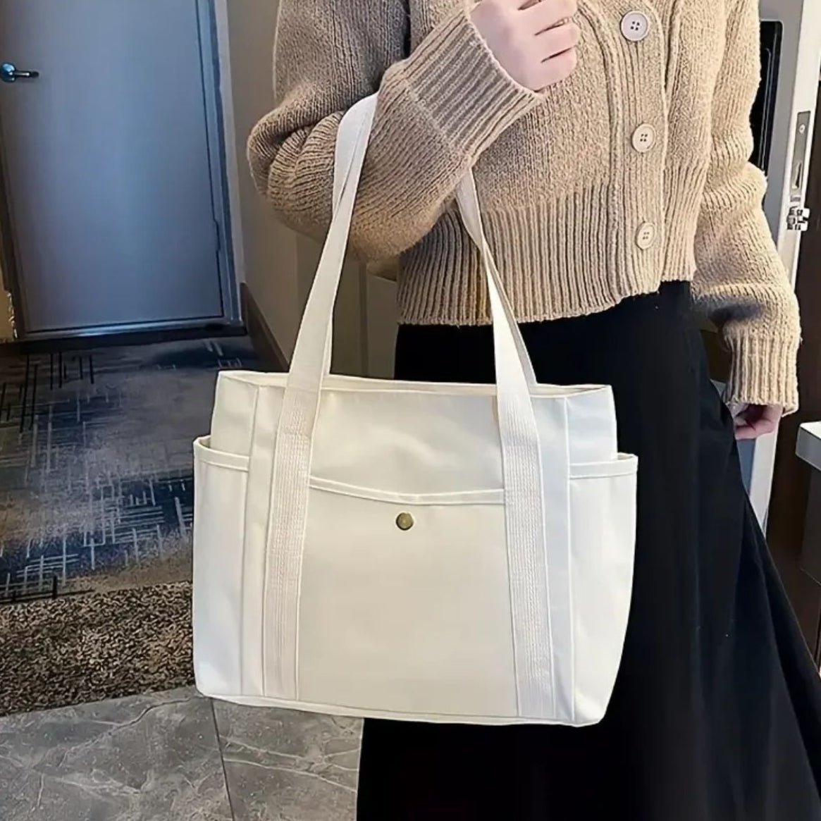Sac pour la maternité beige porté à l’épaule, look sobre et élégant pour la maternité ou les voyages