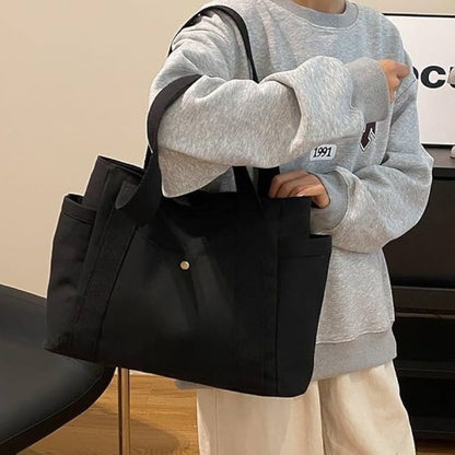 Sac pour la maternité noir porté à l’intérieur, pratique avec poches latérales accessibles