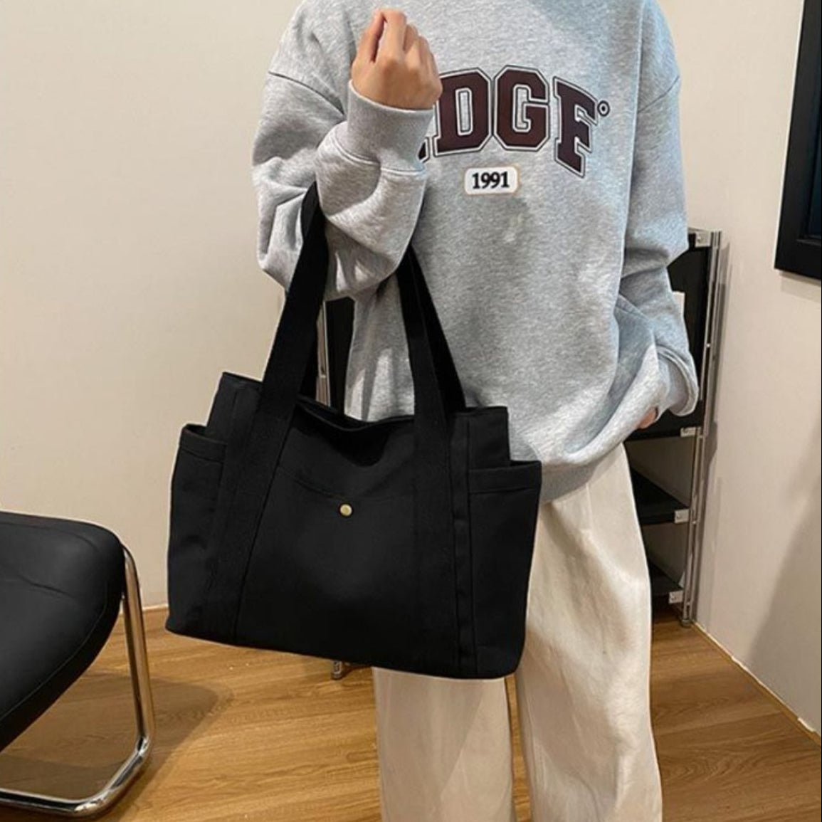 Sac pour la maternité noir porté en main, design minimaliste et pratique au quotidien