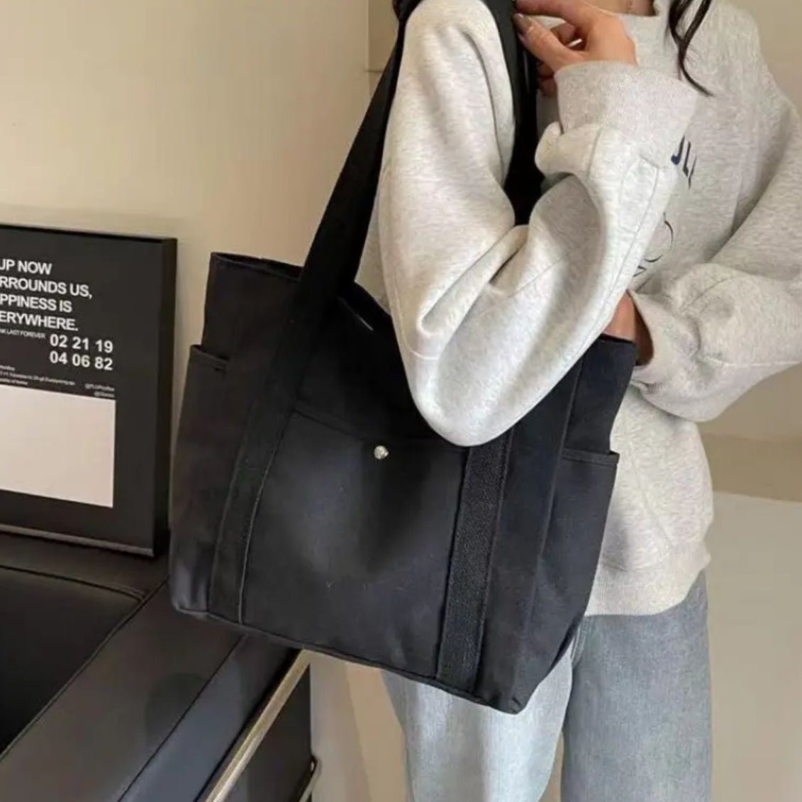 Sac pour la maternité noir porté à l’épaule, style discret et élégant adapté aux sorties