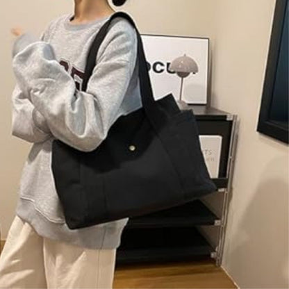 Sac pour la maternité noir porté à l’épaule, format spacieux et confortable pour les déplacements