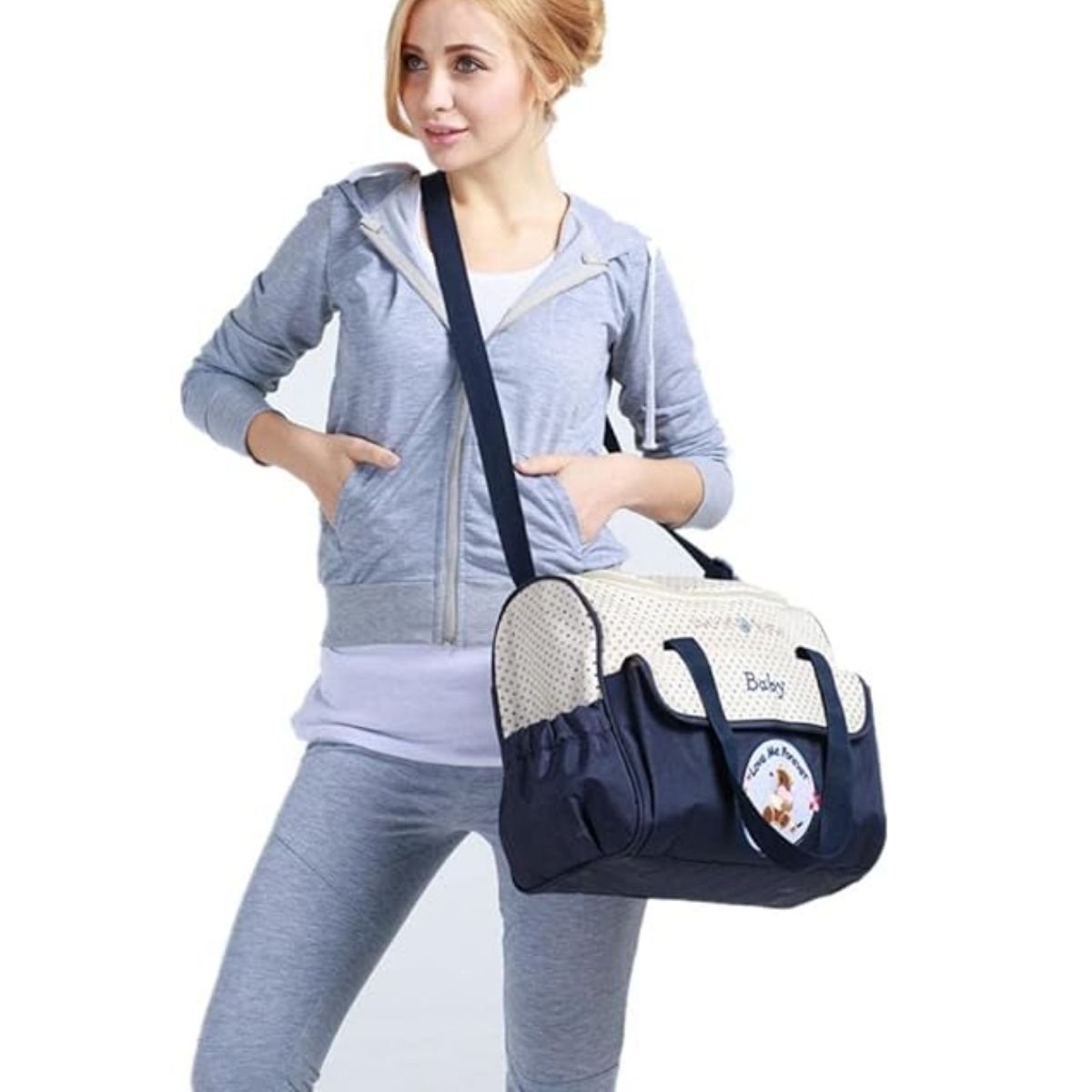 Sac pour la maternité bleu marine porté à l’épaule par un parent, vue frontale